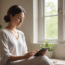 Person using a mental health app in a calm, naturally lit setting to promote emotional wellness.
